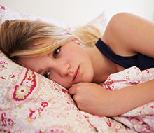 Frustrated woman awake in bed