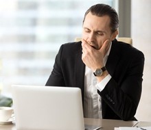 A man at his computer yawning