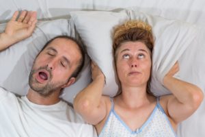 woman frustrated with husband snoring