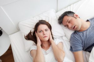 woman upset with man snoring