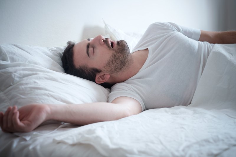 A man with sleep apnea in Columbus snoring in bed.